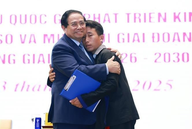 Prime Minister Pham Minh Chinh and Mua A Thi, head of Hang Pu Xi hamlet in Xa Dung commune of Dien Bien province, who saves 90 villagers from flash floods and landslides in the early morning of August 1. (Photo: VNA)