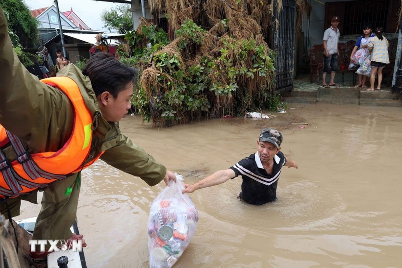 Public security officers in Dak Lak province deliver food supplies to residents in deeply flooded areas along the Banh Lai River. (Photo: VNA)