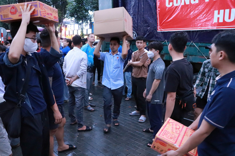 Volunteers busily load 80 tonnes of goods and essential supplies onto emergency relief trucks bound for disaster-affected communities. (Photo: VNA)