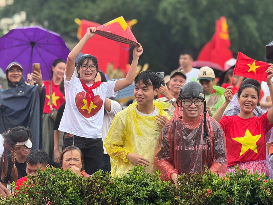 Love and pride outweigh the rain. A moment capturing Hanoians enduring the weather, patiently waiting and cheering for the armed forces. (Photo: VNA)