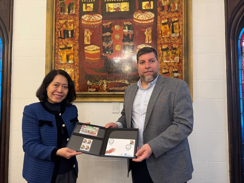 MP Victor Aldaya presents Ambassador Ngo Minh Nguyet with a set of stamps issued by Uruguay's National Post Office in December 2013, commemorating the 20th anniversary of Vietnam-Uruguay diplomatic relations. (Photo: VNA)
